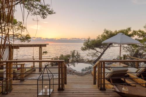 a dock with an umbrella and a body of water at Perdue Hotel in Faralya