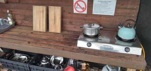 a stove with a tea kettle on top of it at Trees&Seas - Glamping with farm animals in Wilderness