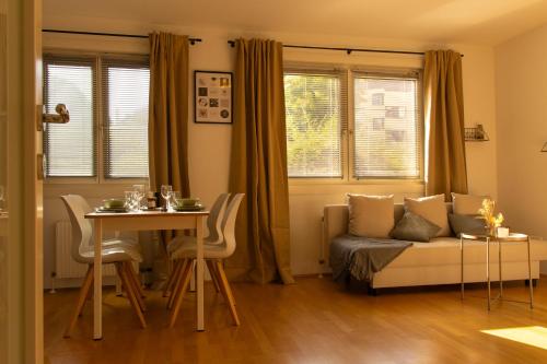 ein Wohnzimmer mit einem Sofa und einem Tisch in der Unterkunft Modern - Calm - Cozy - self CheckIn - stylish new apartment near center - close to U4 in Wien