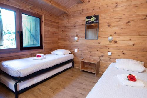 um quarto com 2 camas num chalé de madeira em Mare E Monti Chalets em Porto Pollo