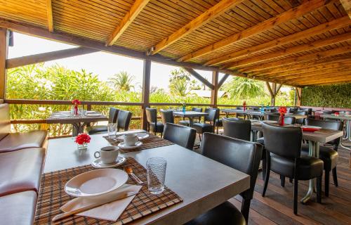 ein Restaurant mit Tischen und Stühlen auf einer Terrasse in der Unterkunft Mare E Monti in Porto Pollo