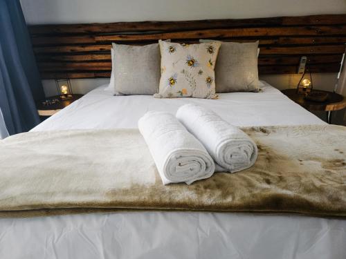 Una cama blanca con dos toallas enrolladas. en Sea Breeze Manor - Gold Unit, en East London