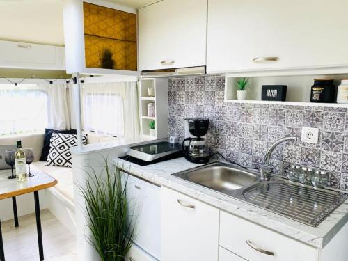 a kitchen with white cabinets and a sink at An iconic 1974 Vintage Caravan in Ioannina