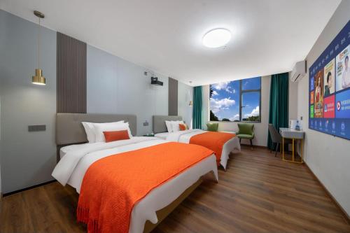 a hotel room with two beds and a desk at Guangzhou Yashay International Apartment - Pazhou Convention and Exhibition Centre in Guangzhou