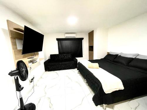 ein Schlafzimmer mit einem großen Bett und einem TV in der Unterkunft Lujoso apto en laureles capacidad Max 8 personas in Medellín
