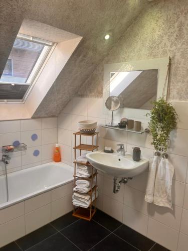 a bathroom with a sink and a tub and a mirror at Plätzchen am Krebsberg für alle Fä(e)lle in Simmerath