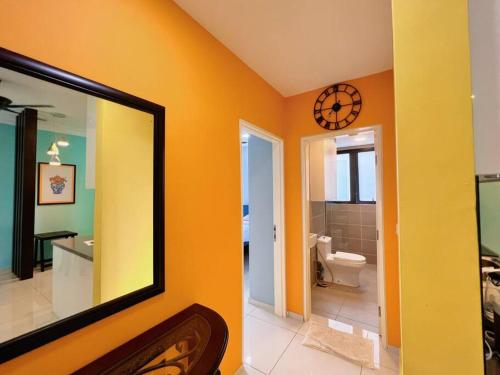 ein Badezimmer mit einem Spiegel und einer Uhr an der Wand in der Unterkunft Homely 2BR Heritage D'Sara @ Link to MRT, Near Thomson Hospital & Sungai Buloh Hospital in Sungai Buloh