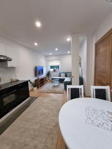 a kitchen and living room with a table and a couch at Lovely Apartment Sarajevo in Sarajevo