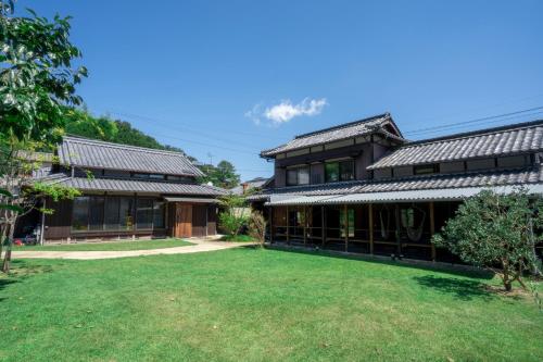 an exterior view of a building with a yard at OMISHIMA SPACE Omoya in Imabari