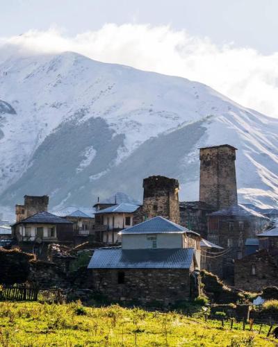 a group of buildings with a mountain in the background at Ela in Ushguli