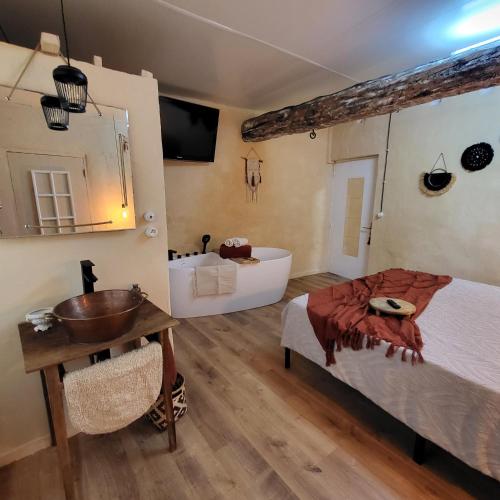 a bedroom with a bed and a sink and a tub at Chambre d'hôtes Gard in Meynes