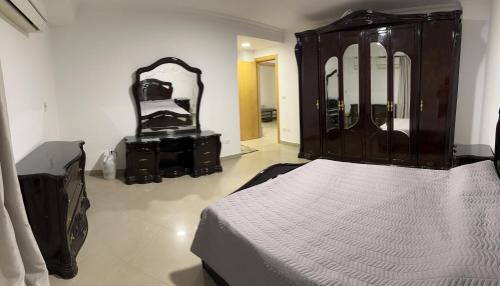 a bedroom with a bed and a dresser and a mirror at Queen plaza Nasr City in Cairo