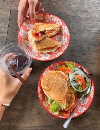 two plates with sandwiches and a salad on a table at Imchai in Pai