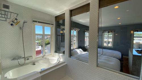 a bathroom with two sinks and a large mirror at Tabinoteitaku Kamakura Yuigahama -Homann Concept- in Kamakura
