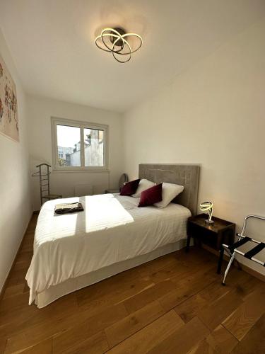 - une chambre avec un grand lit blanc et un lustre dans l'établissement ARENA Center Town, à Reims