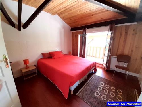 MonbardonにあるLes Houradetsのベッドルーム1室(赤いベッド1台、窓付)