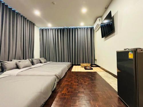 a hotel room with two beds and a television at Chern Chiangmai Boutique in Chiang Mai