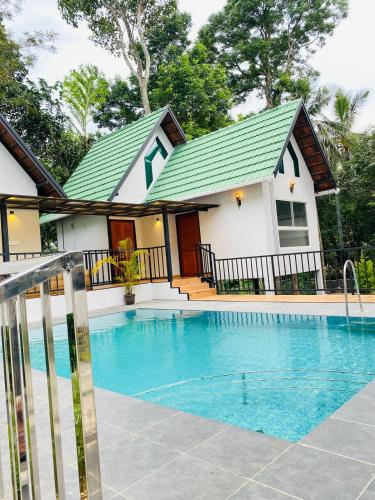 una casa con piscina frente a ella en Regalia Wayanad en Kalpatta