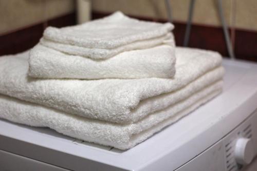 a stack of white towels sitting on top of a washing machine at S1 Apartman in Szombathely