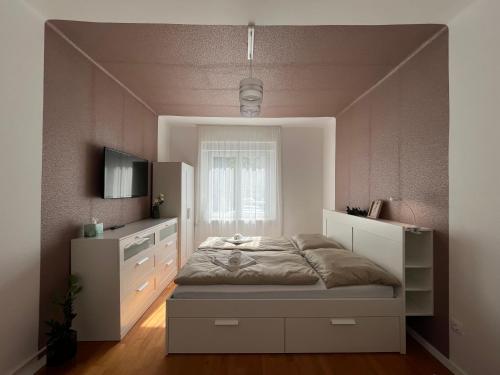 a bedroom with a large bed and a window at S1 Apartman in Szombathely