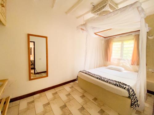 een slaapkamer met een bed en een spiegel bij 611 Sporting Residence in Malindi