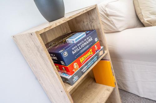 a pile of books in a book shelf next to a bed at Spacious 5 Bedroom House - Sleeps 7 - 3-Car Driveway - Work - Leisure in Wolverhampton