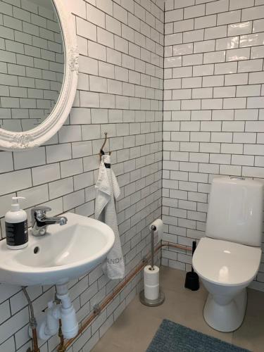 a white bathroom with a sink and a toilet at Le Coq Heureux in Vånga