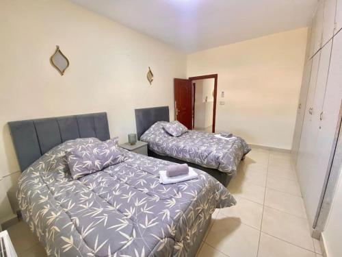 a bedroom with two beds and a mirror at Great location apartment in Amman