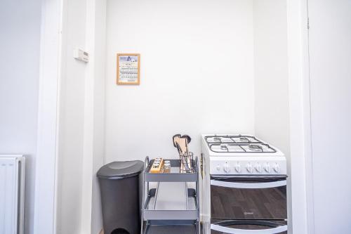 a kitchen with a stove and a trash can at Spacious 5 Bedroom House - Sleeps 7 - 3-Car Driveway - Work - Leisure in Wolverhampton