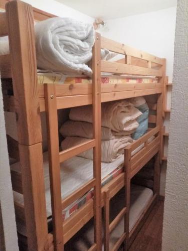 Ce lit superposé en bois se trouve dans un dortoir. dans l'établissement Logement tout confort Val d'Isere, à Le Joseray