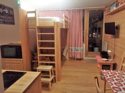 Dormitorio con letto a castello e cucina. di Logement tout confort Val d'Isere a Le Joseray
