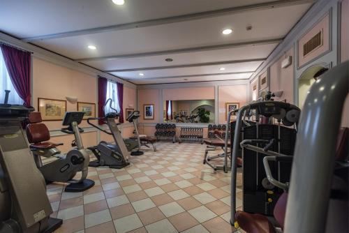 a gym with treadmills and exercise equipment in a room at Grand Hotel Liberty in Riva del Garda
