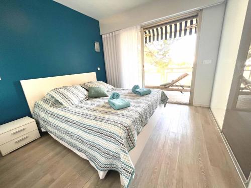 Un dormitorio con una cama con dos toallas azules encima. en SPLENDIDE 3 PIECES VUE MER, en Antibes