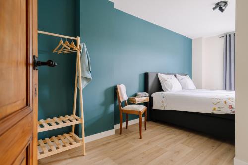 1 dormitorio con paredes azules, 1 cama y 1 silla en BuitenGewoon Libeek, en Sint Geertruid