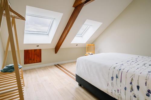 a bedroom with two skylights and a bed in a attic at BuitenGewoon Libeek in Sint Geertruid