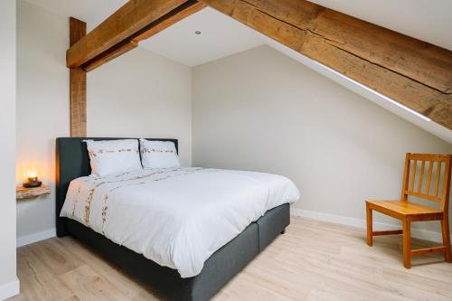 a bedroom with a bed and a wooden chair at BuitenGewoon Libeek in Sint Geertruid