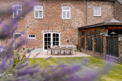 a patio with a table and chairs in front of a brick building at BuitenGewoon Libeek in Sint Geertruid