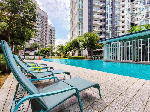 a group of chairs sitting next to a swimming pool at Medini Signature by JBcity Home in Nusajaya