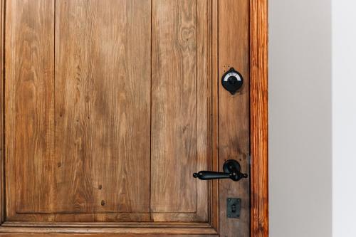 a wooden door with a black door knocker on it at BuitenGewoon Libeek in Sint Geertruid