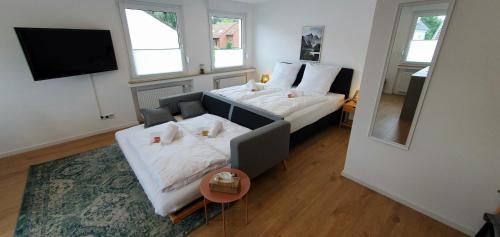 ein Schlafzimmer mit einem Bett, einem Sofa und einem Spiegel in der Unterkunft CityChalet-neu renoviert-Küche-ruhig-Parkplatz in Bochum