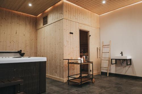 cocina con paredes de madera, estante y escalera en Forest Apartment, en Augustów