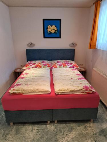 un letto con due cuscini sopra in una camera da letto di Haus Trojer a Matrei in Osttirol