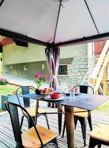 une table et des chaises avec un parasol sur une terrasse dans l'établissement les loges de l'Arpenaz, à Magland