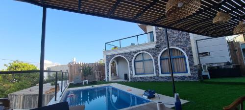 une maison avec une piscine dans la cour dans l'établissement סוויטה בכפר ירכא, à Yarka