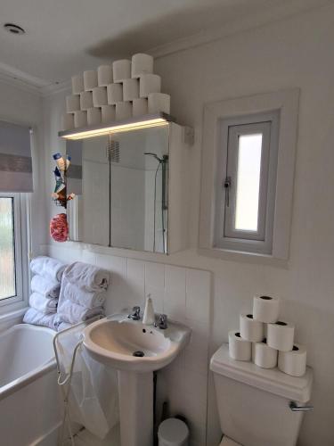 a bathroom with a sink and a toilet and a tub at The White House in Waltham Cross