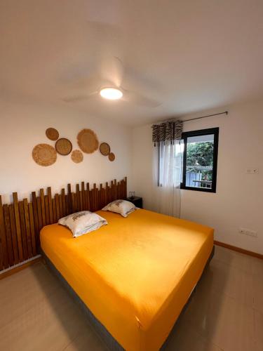una camera con un grande letto giallo di AFRICA a La Possession