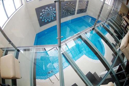 - un escalier en verre menant à une piscine dans un bâtiment dans l'établissement Iceberg Apartment 50, à Borovets