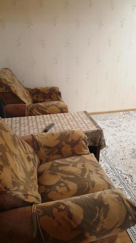 2 lits sont installés dans une pièce avec un mur dans l'établissement Роза, à Bishkek