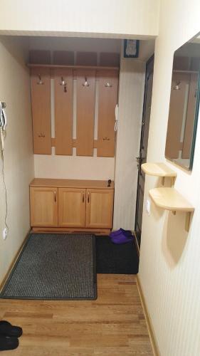 ビシュケクにあるРозаの木製のキャビネットと絨毯が置かれた空っぽの部屋