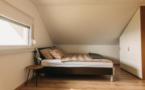 Apartma Hiša na Ravnah في Pišece: غرفة نوم صغيرة مع سرير في العلية
